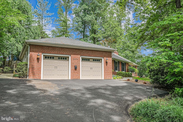 3404 Rustic Way Ln, Falls Church, VA 22044 - view of home's exterior featuring driveway, an attached garage, brick siding, and a shingled roof