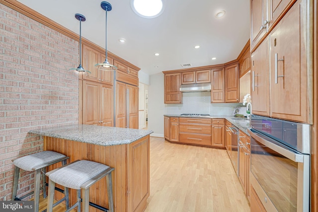 3404 Rustic Way Ln, Falls Church, VA 22044 - kitchen with appliances with stainless steel finishes, under cabinet range hood, a peninsula, light wood-type flooring, and light stone countertops