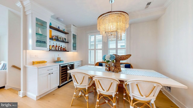 625 Bay Ave, Ocean City, NJ 08226 - dining room with wine cooler, crown molding, a dry bar, light wood finished floors, and a chandelier