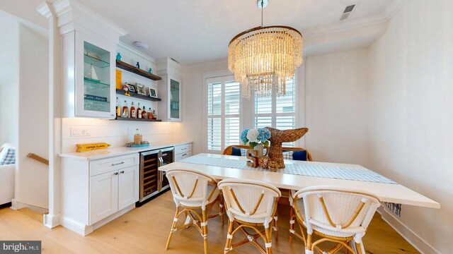 625 Bay Ave, Ocean City, NJ 08226 - dining space featuring wine cooler, crown molding, a dry bar, light wood-style floors, and a chandelier