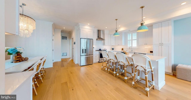 625 Bay Ave, Ocean City, NJ 08226 - kitchen featuring stainless steel appliances, light wood finished floors, wall chimney exhaust hood, white cabinets, and recessed lighting