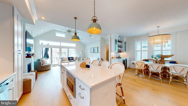 625 Bay Ave, Ocean City, NJ 08226 - kitchen featuring a kitchen bar, light wood-style floors, white cabinetry, healthy amount of natural light, and vaulted ceiling