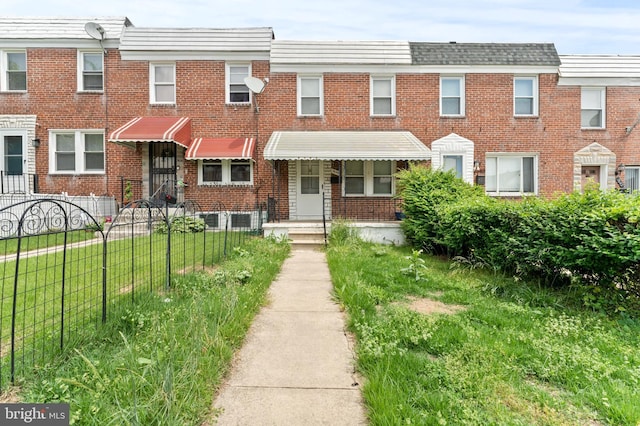 view of property with brick siding and fence