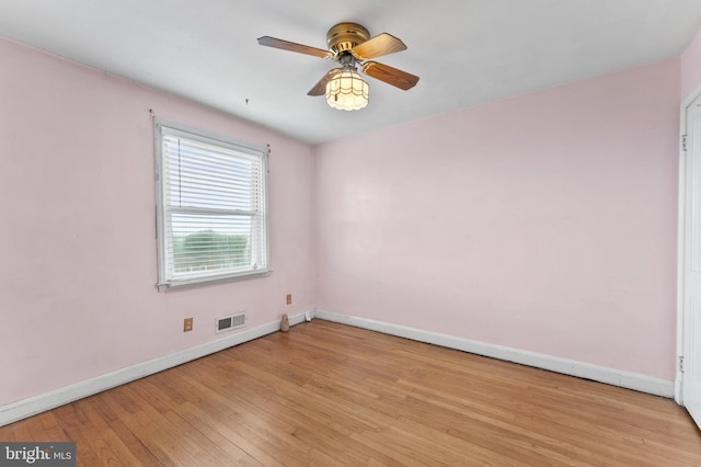 unfurnished room featuring baseboards, a ceiling fan, and light wood-style flooring