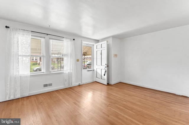 empty room with light wood finished floors and baseboards