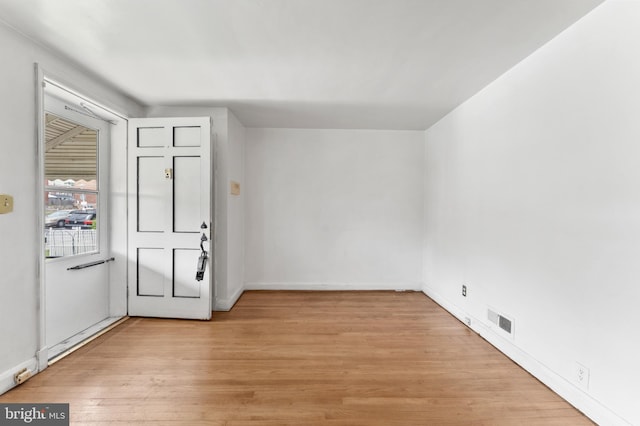 entryway with light wood finished floors and baseboards
