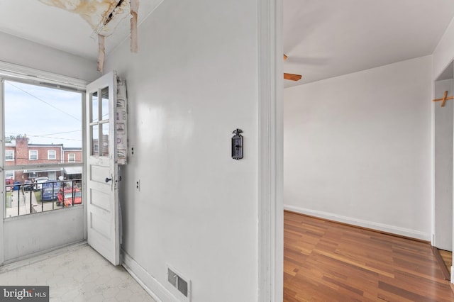 hall with light wood finished floors and baseboards