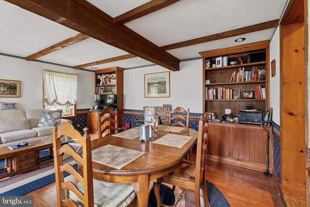 dining space featuring light wood-style flooring and beam ceiling