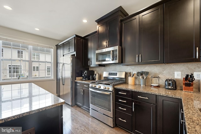 43008 Paris Gap Sq, Ashburn, VA 20148 - kitchen with appliances with stainless steel finishes, light stone countertops, backsplash, light wood-style floors, and recessed lighting