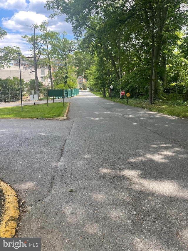 view of asphalt street with curbs and traffic signs