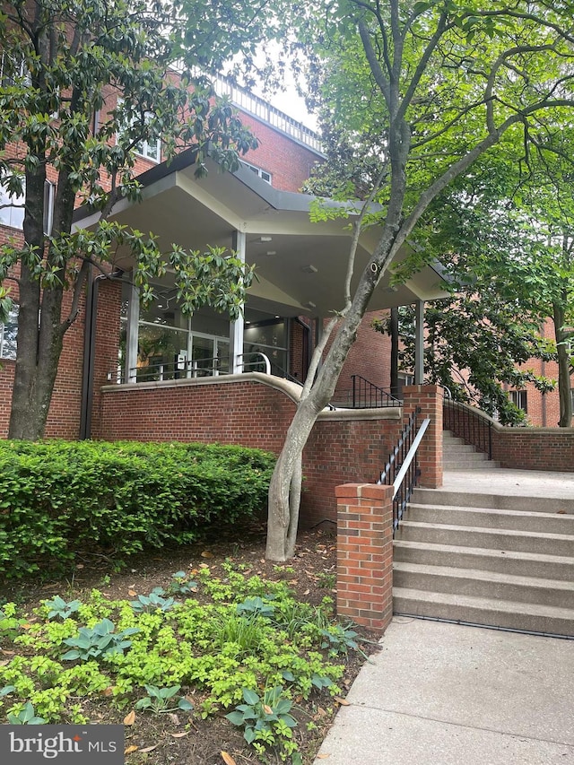 view of front of property with brick siding and stairs