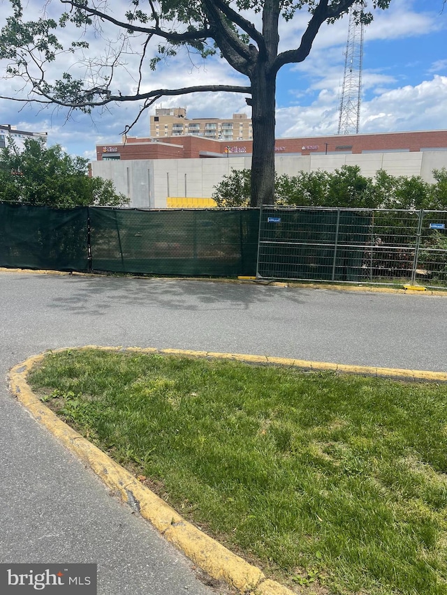 view of asphalt road with curbs