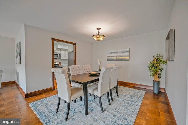 2501 Calvert St NW Unit 306, Washington, DC 20008 - dining space featuring baseboards, a chandelier, and wood finished floors