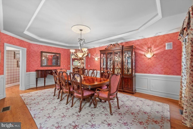 217 Rising Meadow Way E, Stroudsburg, PA 18302 - dining space featuring a chandelier, wallpapered walls, a tray ceiling, a wainscoted wall, and light wood-type flooring