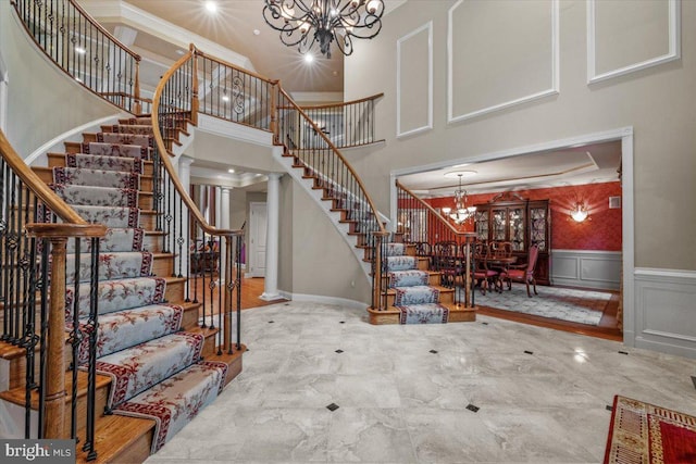 217 Rising Meadow Way E, Stroudsburg, PA 18302 - entryway with a chandelier, a high ceiling, stairway, a wainscoted wall, and a decorative wall