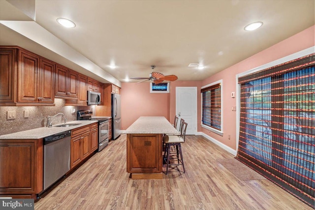 217 Rising Meadow Way E, Stroudsburg, PA 18302 - kitchen with appliances with stainless steel finishes, a sink, a kitchen breakfast bar, a ceiling fan, and light wood-style floors
