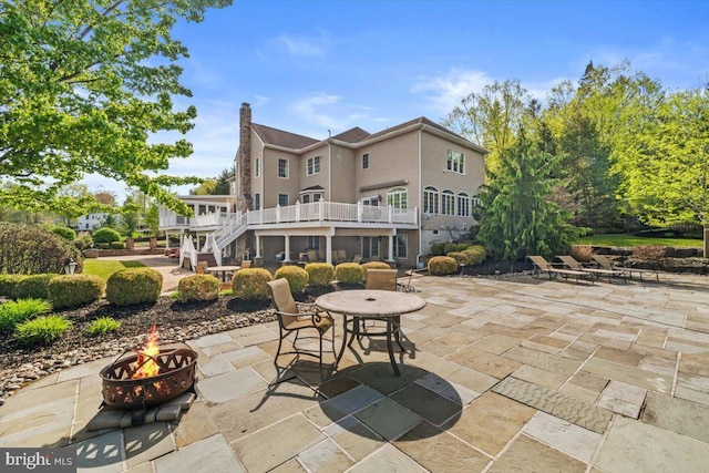 217 Rising Meadow Way E, Stroudsburg, PA 18302 - back of property with a fire pit, stairs, a patio, and a chimney