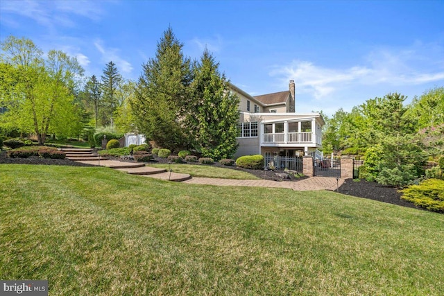217 Rising Meadow Way E, Stroudsburg, PA 18302 - back of house with a sunroom, a chimney, and a gate