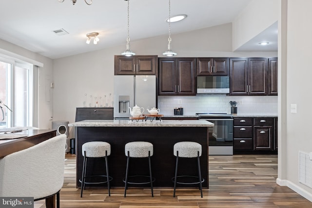 370 Juniper Ct, Herndon, VA 20170 - kitchen featuring refrigerator with ice dispenser, stainless steel range with electric cooktop, white microwave, vaulted ceiling, and decorative backsplash
