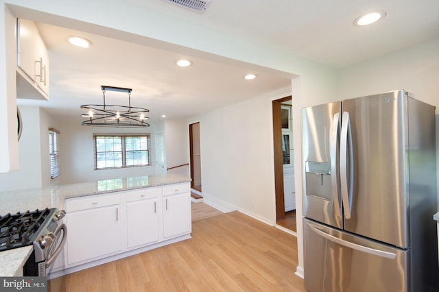 7 Hatsawap Rd, Cambridge, MD 21613 - kitchen featuring appliances with stainless steel finishes, white cabinetry, light wood-style flooring, recessed lighting, and a chandelier