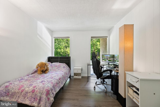 bedroom featuring dark wood-type flooring and a desk