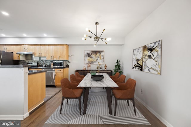 dining space featuring a chandelier, light wood-style flooring, baseboards, and recessed lighting