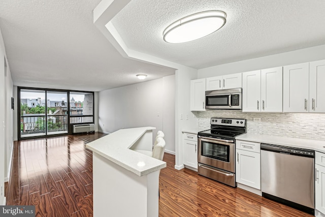 233 S 6th St Unit 411D, Philadelphia, PA 19106 - kitchen with stainless steel appliances, a textured ceiling, open floor plan, tasteful backsplash, and dark wood-type flooring