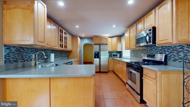 38 Ward Ave, Audubon, NJ 08106 - kitchen with appliances with stainless steel finishes, a sink, light brown cabinets, arched walkways, and light tile patterned floors