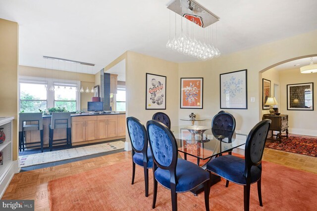 dining room featuring arched walkways and baseboards