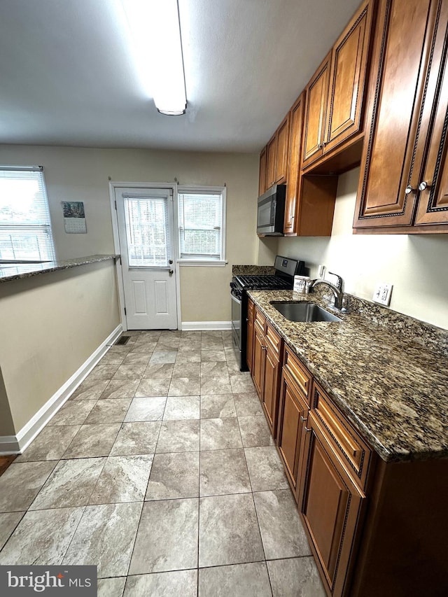 912 Evesham Ave, Baltimore, MD 21212 - kitchen with appliances with stainless steel finishes, a sink, plenty of natural light, and baseboards