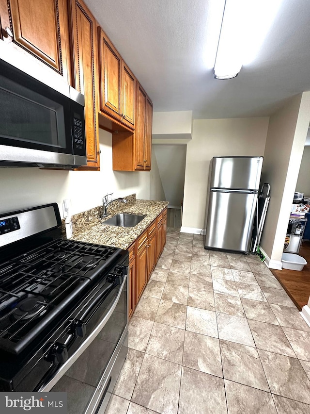 912 Evesham Ave, Baltimore, MD 21212 - kitchen with appliances with stainless steel finishes, a sink, baseboards, and light stone countertops