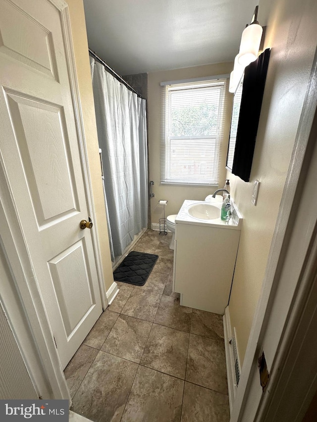 912 Evesham Ave, Baltimore, MD 21212 - full bathroom with vanity, toilet, a shower with shower curtain, and baseboards