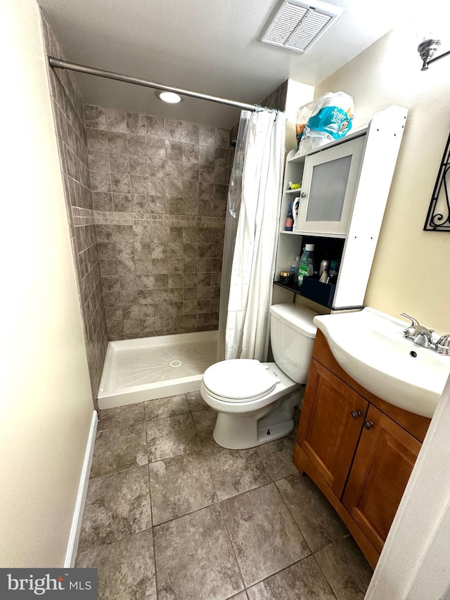 912 Evesham Ave, Baltimore, MD 21212 - bathroom with toilet, vanity, tiled shower, tile patterned flooring, and baseboards