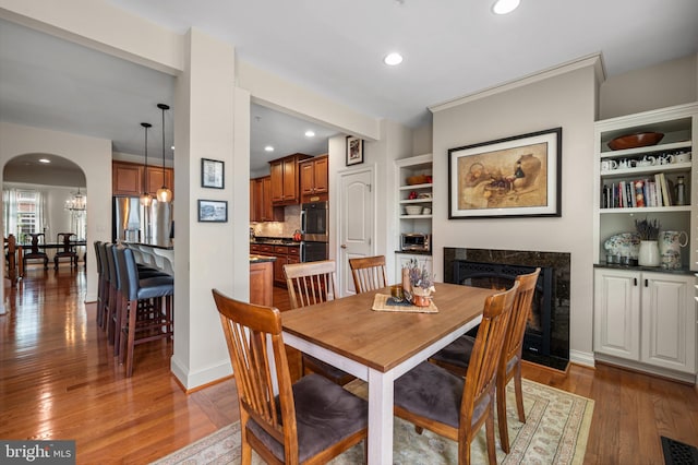 7311 Trappe St, Fulton, MD 20759 - dining space featuring a fireplace, arched walkways, wood finished floors, and recessed lighting