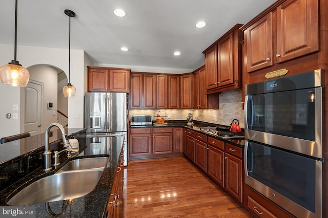 7311 Trappe St, Fulton, MD 20759 - kitchen with a sink, appliances with stainless steel finishes, arched walkways, dark stone counters, and recessed lighting
