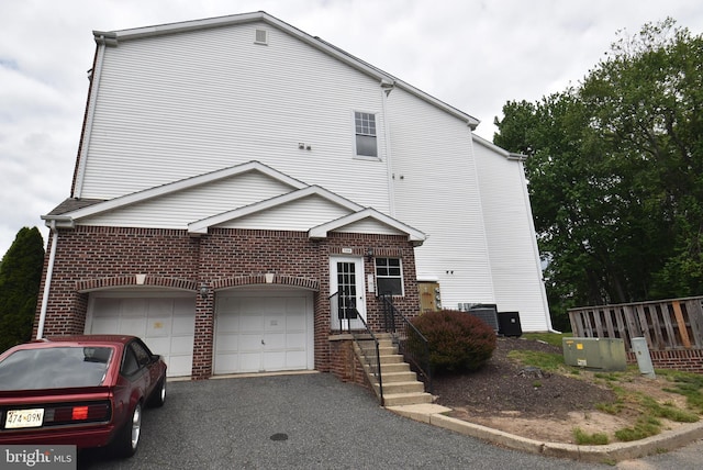1304 Cranesbill Ct Unit 304, Belcamp, MD 21017 - view of front of house with brick siding, asphalt driveway, central air condition unit, and an attached garage