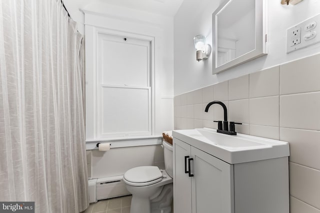 1112 Randall Ave, Upper Chichester, PA 19061 - bathroom featuring a baseboard heating unit, toilet, vanity, tile walls, and tile patterned flooring