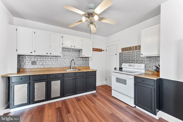 1112 Randall Ave, Upper Chichester, PA 19061 - kitchen with electric stove, a sink, white cabinets, and tasteful backsplash