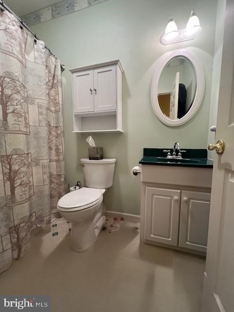 bathroom with toilet, vanity, baseboards, and a shower with shower curtain