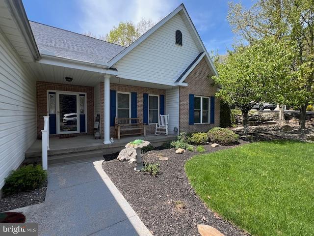 property entrance with brick siding and a porch
