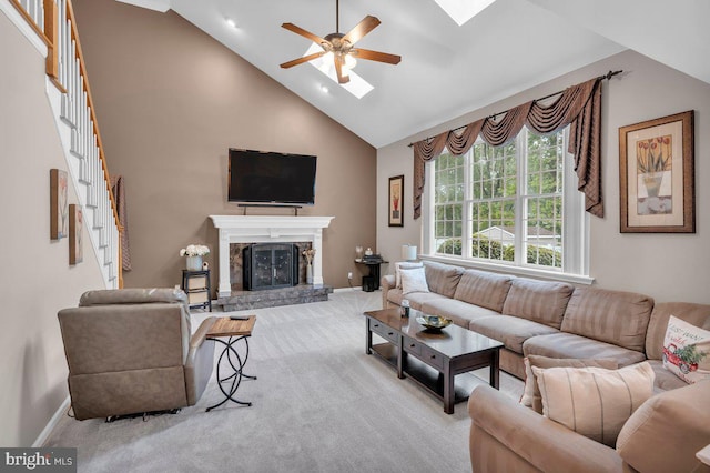 carpeted living area featuring high vaulted ceiling, ceiling fan, stairway, baseboards, and a fireplace