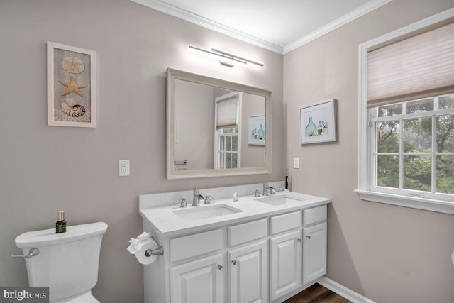 bathroom with toilet, ornamental molding, and double vanity