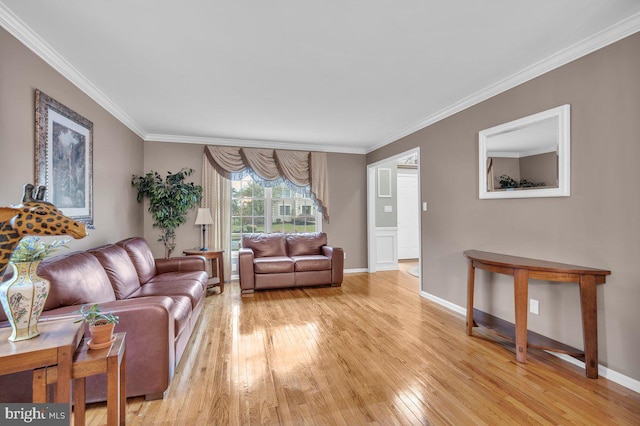 living area featuring light wood-type flooring, ornamental molding, and baseboards