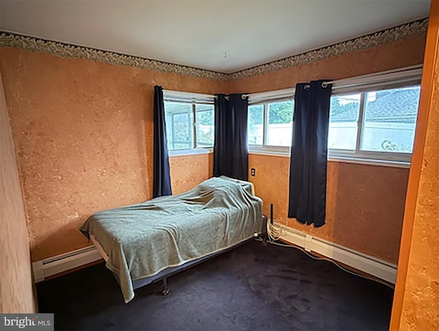bedroom with a baseboard radiator, a textured wall, baseboards, and carpet flooring