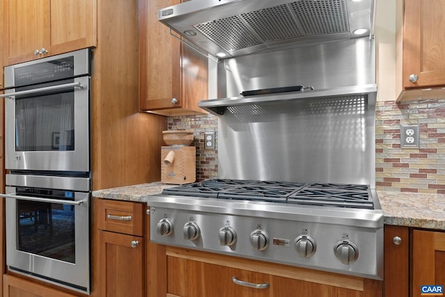 2657 Coralberry Pl, Charlottesville, VA 22911 - kitchen featuring stainless steel appliances, decorative backsplash, brown cabinetry, and ventilation hood