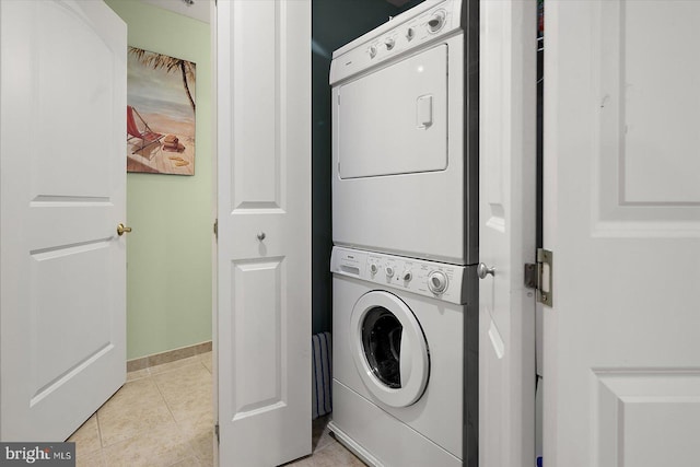 301 14th St Unit 308/309, Ocean City, MD 21842 - washroom featuring stacked washer / drying machine, light tile patterned floors, and baseboards