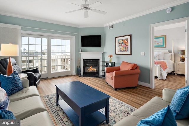 301 14th St Unit 308/309, Ocean City, MD 21842 - living area with wood finished floors, a fireplace, a ceiling fan, crown molding, and baseboards