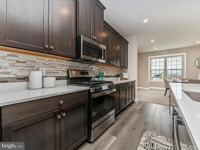 14716 Spring Haven Ln, Laurel, MD 20707 - kitchen featuring stainless steel appliances, dark brown cabinetry, decorative backsplash, light countertops, and recessed lighting
