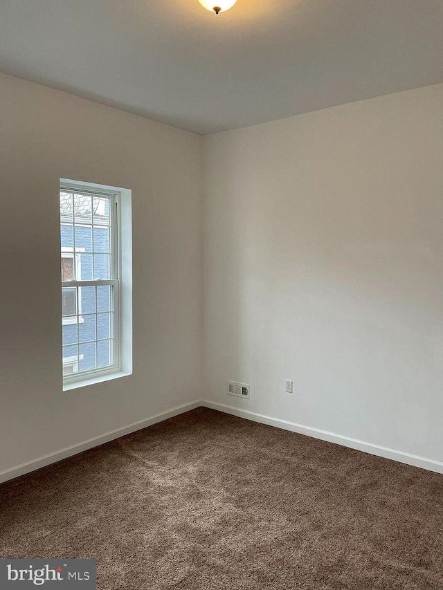 carpeted empty room featuring baseboards