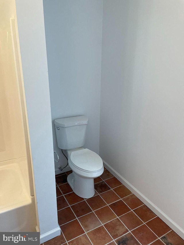 bathroom featuring tile patterned floors, baseboards, and toilet